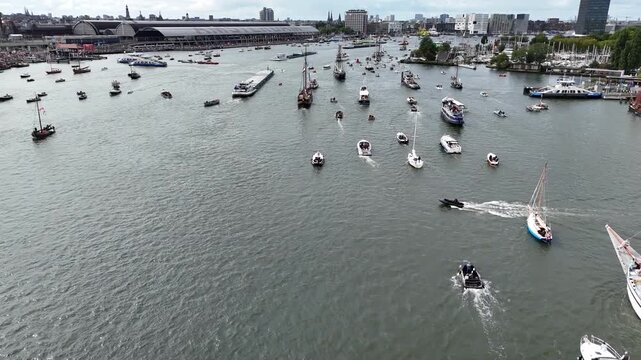 Amsterdam, Netherlands 23 August 2025: Drone footage of Sail 2025 - Sailing Parade in Amsterdam. Enjoy the view of the sail boats by the docks and in the canals of Amsterdam from a Birds Eye view