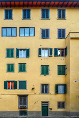 Facade of a traditional Italian residential building with multiple windows and shutters