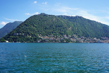 Fototapeta premium Lago di Como Italia spettacolare vista paesaggio naturale casette bellissime vita italiana architettura barche lago verde natura ville italiane gita in barca destinazione. Fotografie raw senza filtri
