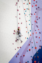 The girl climbs the climbing wall.