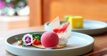 Gourmet dessert plate featuring vibrant raspberry mousse, artistic chocolate shards, fresh fruits,...
