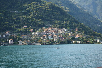 Fototapeta premium Lago di Como Italia spettacolare vista paesaggio naturale casette bellissime vita italiana architettura barche lago verde natura ville italiane gita in barca destinazione. Fotografie raw senza filtri