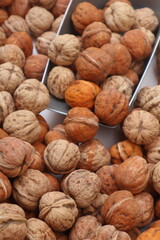 closeup of Walnuts in a bowl at the market with a scoop taking out walnuts, fresh nuts, healthy food