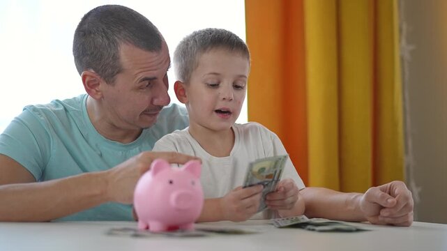 Father supports child during money counting session at home table. Saving steps shown with dollar bills. Finance repeated clearly. Piggybank adds support as father builds saving habits slowly
