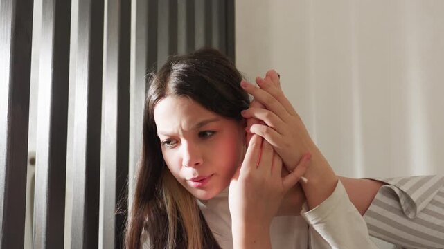 School girl in striped pajamas holds leg to ear like phone, supporting foot with hands, focused expression while pretending conversation, playful bedroom moment, then lowers leg after call