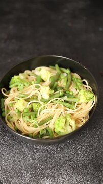 Spaghetti vegetables green peas, broccoli, string beans, kohlrabi vegetarian pasta tasty snack fresh delicious gourmet food background on the table rustic top view copy space vegan food