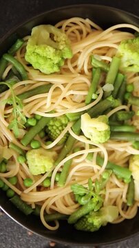 Spaghetti vegetables green peas, broccoli, string beans, kohlrabi vegetarian pasta tasty snack fresh delicious gourmet food background on the table rustic top view copy space vegan food