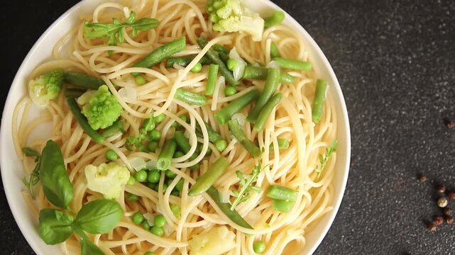 Spaghetti vegetables green peas, broccoli, string beans, kohlrabi vegetarian pasta tasty snack fresh delicious gourmet food background on the table rustic top view copy space vegan food
