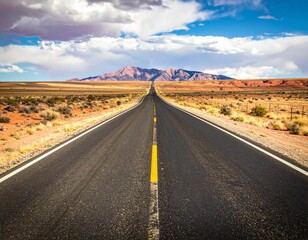 Empty winding road disappearing into desert horizon.