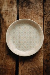 Elegant ceramic plate with delicate floral patterns placed on rustic wooden surface