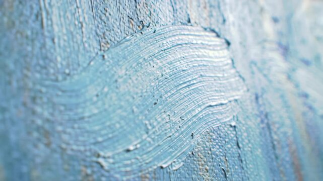 Close-up of light blue paint strokes on a textured canvas.