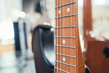 Close-up of an expensive electric guitar seen on its vertical stand within a venue in Britain. Part of a rock group which is doing rehearsals.