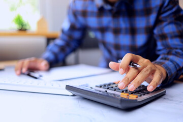 Accounting concept with hand of accountant using calculator to calculate company's income,...