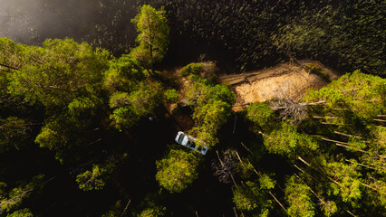 Explore the stunning scenery of Hossa National Park. Lush green forests frame the lake, inviting nature lovers for outdoor adventures and relaxation in a serene setting with a camper van in the forest