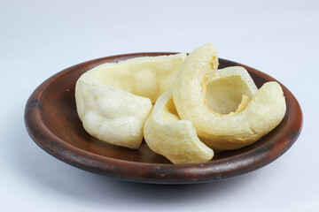 Kerupuk Kulit or cow skin crackes. Crackers made from processed genuine cowhide. They are cleaned, dried in the sun, and then fried. A typical Indonesian cracker. Isolated on a white background.