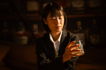 Businesswoman drinking alcohol holding a glass of whiskey 