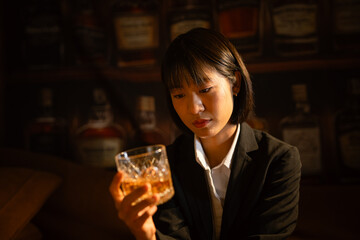 Businesswoman drinking alcohol holding a glass of whiskey 