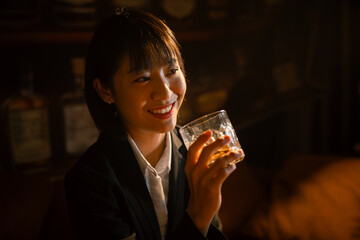  Closeup business woman holding a glass of whiskey