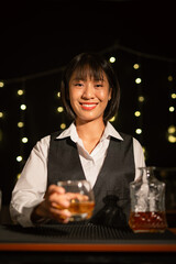 Professional female bartender preparing alcoholic drinks in a bar