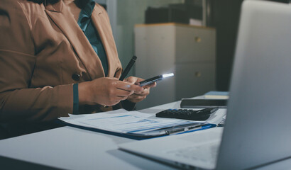 Close-up of businessman's hands making notes, mobiles, chart, desk, office