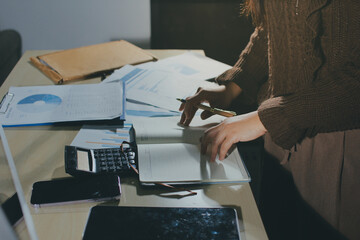 Close-up of businessman's hands making notes, mobiles, chart, desk, office