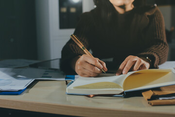 Close-up of businessman's hands making notes, mobiles, chart, desk, office
