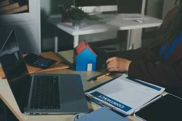 Customer signing a real estate contract in real estate agency.