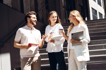 Business professionals collaborating outdoors during a coffee break