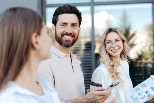 Colleagues smiling during informal outdoor business meeting