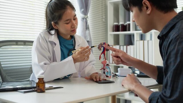 A man suffering from a urinary tract infection visits a doctor at the examination table in a hospital. Symptoms. Talk about enlarged prostate. Male reproductive system. Asian doctor.