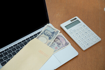 パソコンとお金と封筒と計算機