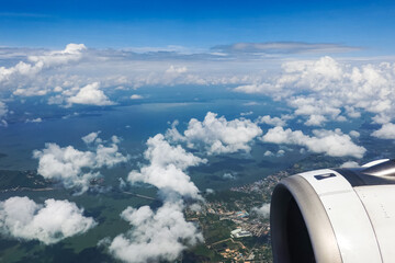 Aerial view from an airplane window over a cloudy island on a clear day. © All times 