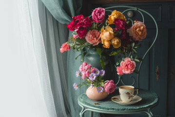 Summer bouquet of english roses with cup of tea