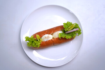Egg bun with onion, salad leaves on white plate 