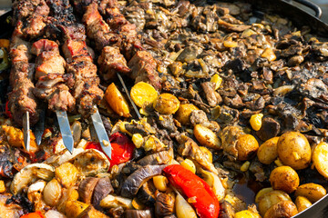 Grilled Meat Skewers and Roasted Vegetables on Open Fire