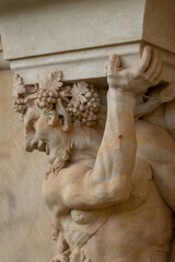 Close-up of a detailed baroque stone sculpture of an atlas figure holding architectural weight,...