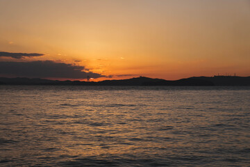 Fototapeta premium 渋川海岸、美しい夕日が海岸線に沈む風景、岡山、日本