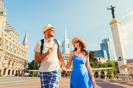 Batumi, Georgia - 19th august, 2025: Couple of tourists having fun walking in Batumi city street on holiday - Happy friends laughing together on vacation - People and holidays concept. Medea statue