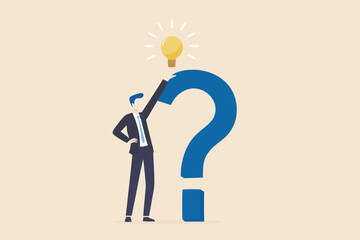 Businessman holding a lightbulb above a giant question mark symbolizing a brilliant idea or solution