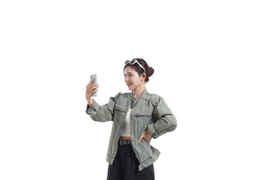 Selfie Moment: A stylish woman captures a moment, holding a mobile phone aloft with a beaming smile, dressed casually and enjoying the simple pleasure of a selfie. - Powered by Adobe