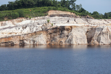 Layered cliff beside calm blue water