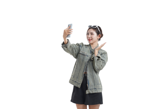 Selfie Time: A cheerful young woman, framed against a neutral background, captures a selfie with her phone, expressing the spirit of connectivity and modern lifestyle.
