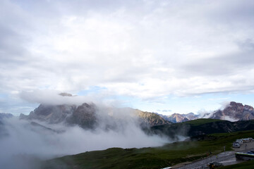 Majestic mountain landscape with clouds and mist enveloping the peaks in the Dolomites region of Italy