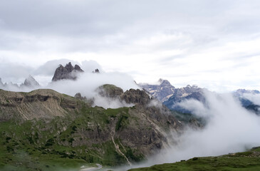  Majestic Dolomite mountains shrouded in mist with lush green valleys and dramatic cloud formations in the background