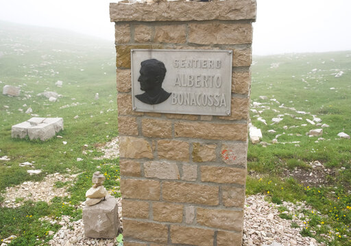 Alto Adige, Italy - July 09, 2025: Alberto Bonacossa trail marker in a misty landscape with rocky terrain and green grass surrounding the area