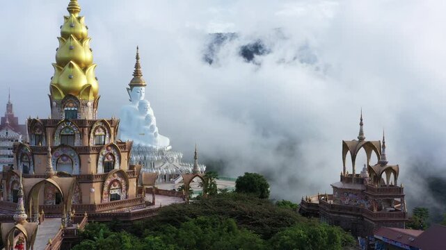 Clouds or fog covering the mountain, green forest with trees. Beautiful morning scene, golden light, and a sea of fog floating above Aerial view of wat phra thart pha sorn kaew in Khaok. 