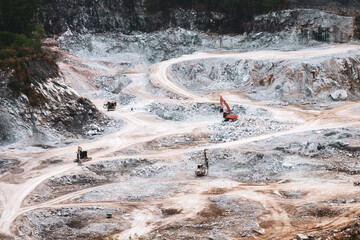 Quarry Excavation: A panoramic view of an active quarry, showcasing heavy machinery meticulously excavating the land. The raw, textured landscape offers a glimpse into the industrial process.