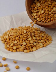 Dried yellow split peas spilling from a bowl