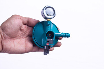 Hand holding LPG gas regulator with pressure gauge on white background, equipment for propane cylinder connection and household cooking safety control