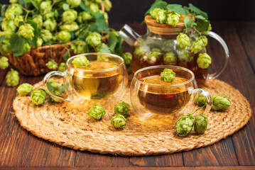 Hop Tea with Fresh Hops in Glass Cups and Teapot on Rustic Background
